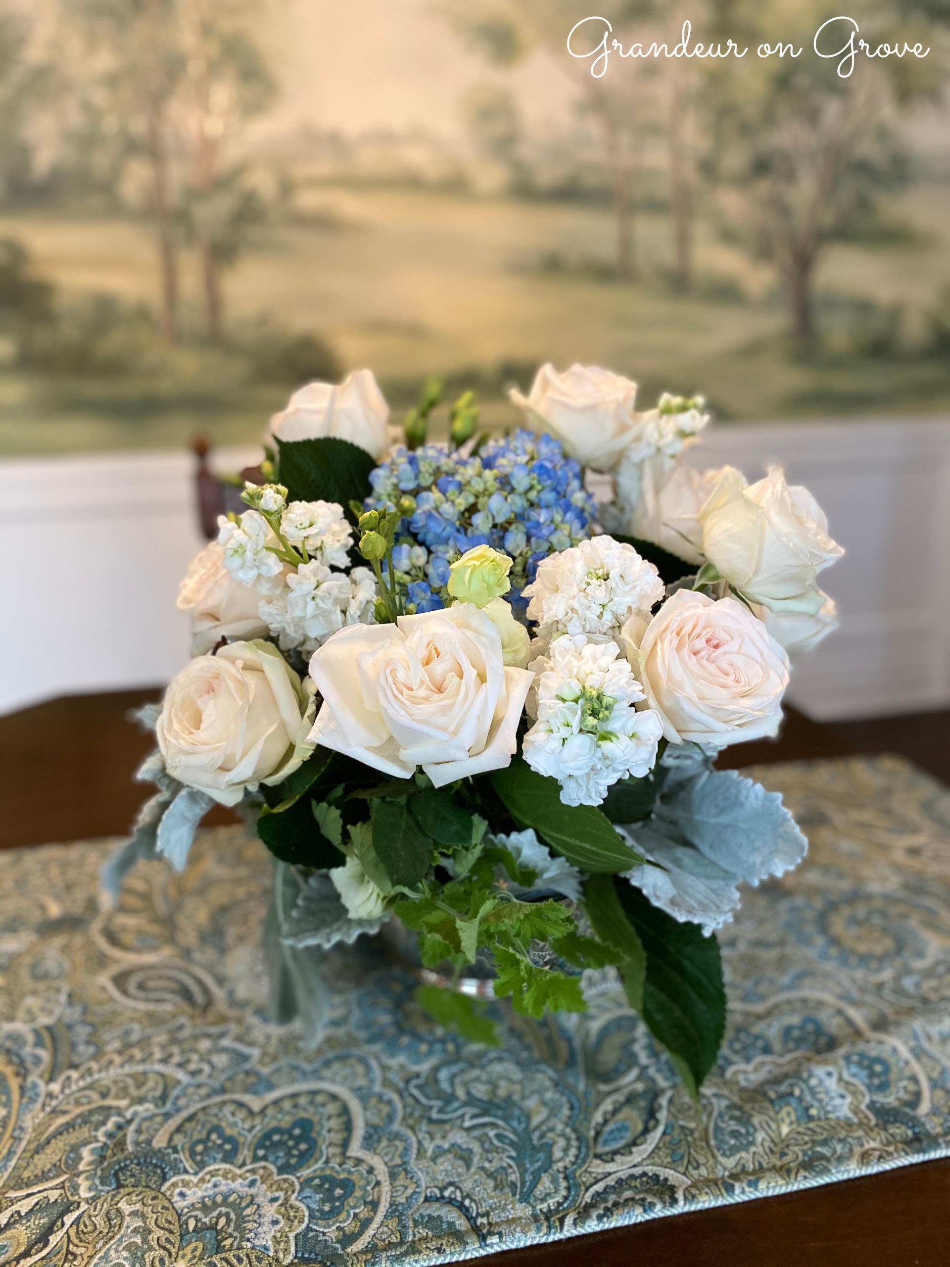 A white and blue floral arrangement sits on a table