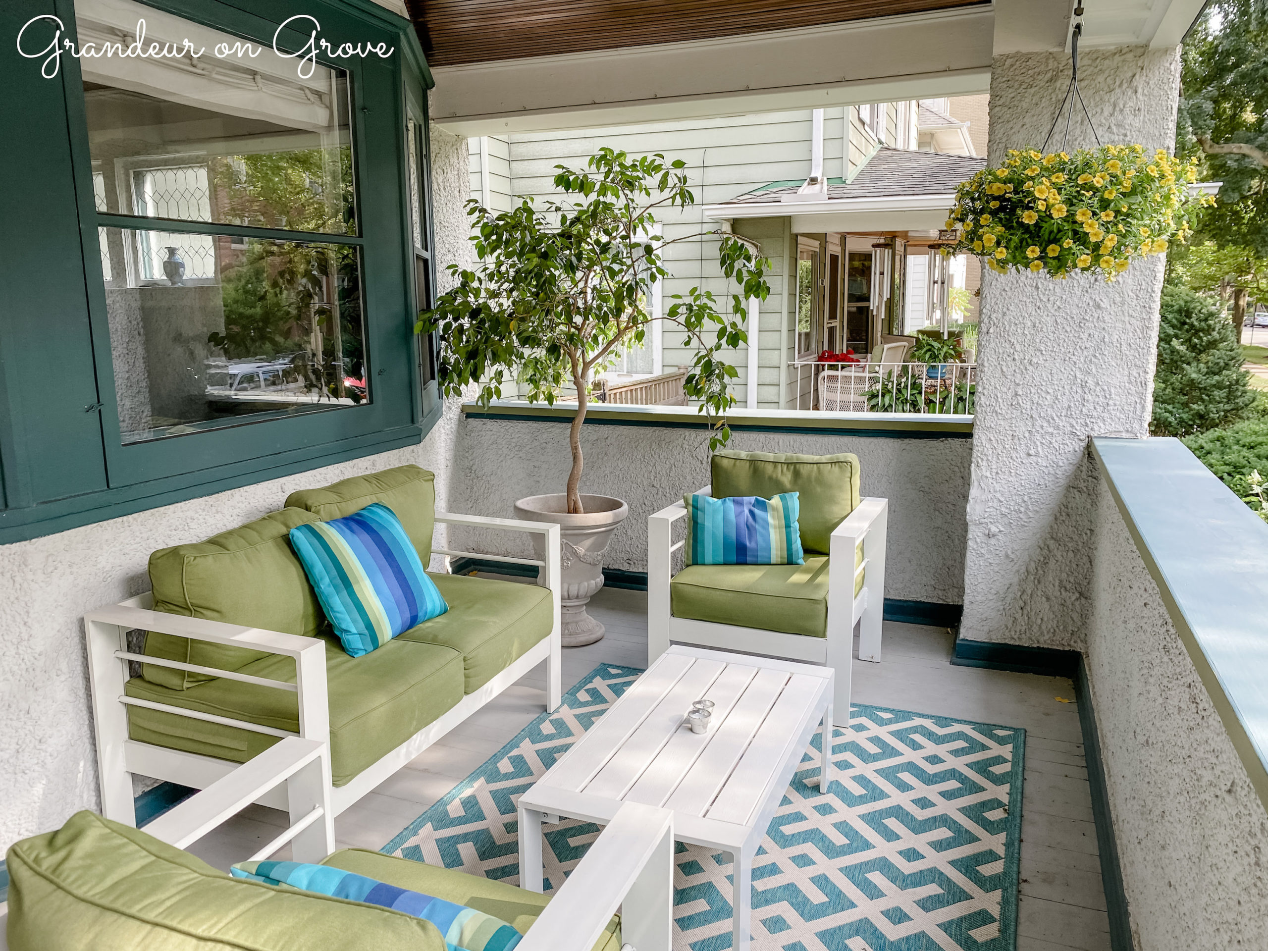 A front porch patio set with decorative flowers and trees