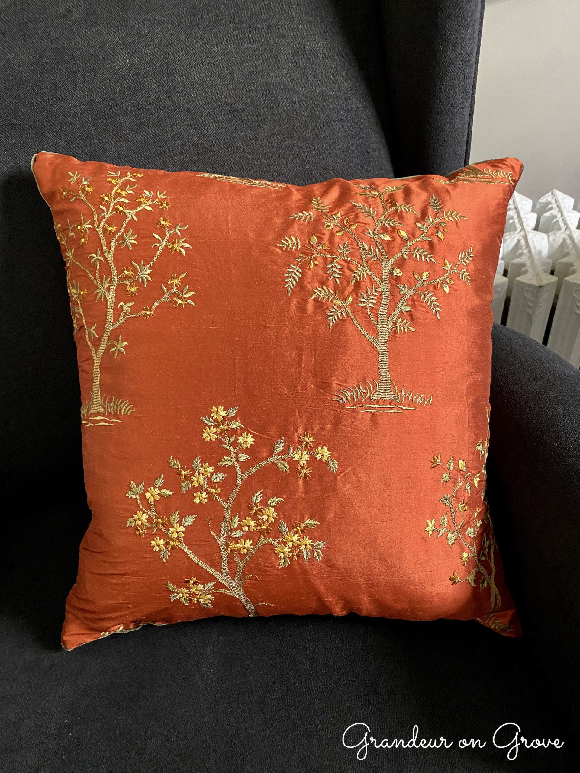 A silk embroidered pillow depicting trees